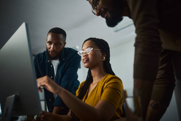 A motivated entrepreneurs working tirelessly at a desktop computer, showcasing their dedication to success. Their focused expressions and engaged body language convey their commitment to accomplishing their goals even during late hours.